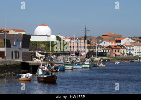 Angelboote/Fischerboote am Fluss Ave in Vila do Conde, nördlich von Porto, Portugal. Die weiße Kuppel der Capela Do ist Socorro im Hintergrund. Stockfoto