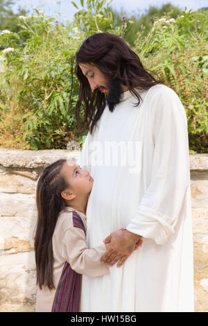 Biblische Szene, in der Jesus sagt: Lasst die Kinder kommen zu mir, ein kleines Mädchen Segen. Historisches Reenactment an einem alten Brunnen. Stockfoto