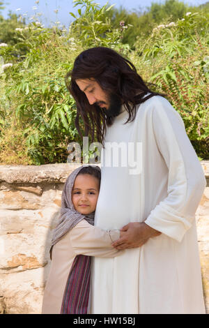 Biblische Szene, in der Jesus sagt: Lasst die Kinder kommen zu mir, ein kleines Mädchen Segen. Historisches Reenactment an einem alten Brunnen. Stockfoto