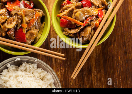 Chinesische klebrige Schweinefleisch Rinderfilet gebraten mit einem süßen und herzhaften Soße mit gekochtem Reis serviert Stockfoto