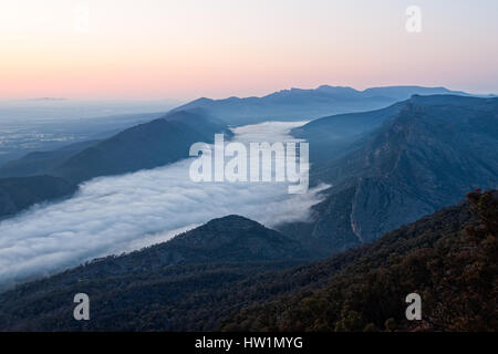 Wolken im Tal und der Wonderland Range bei Sonnenaufgang - vom Schnellboot Aussichtspunkt in den Grampians, Victoria, Australien Stockfoto