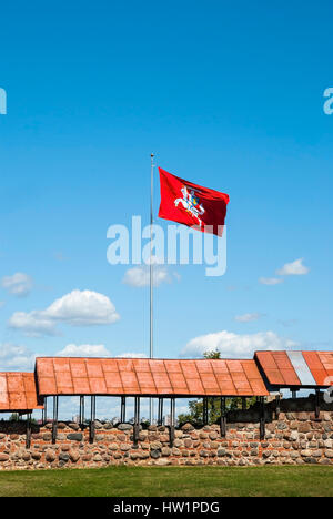 Blick auf rot wehende Flagge in Burg Kaunas, Litauen. Blauer Himmel mit Wolken im Hintergrund Stockfoto