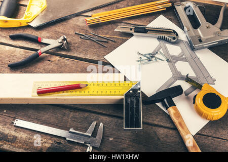 DIY-Tischlerwerkzeuge auf alten Holztisch in Werkstatt Stockfoto