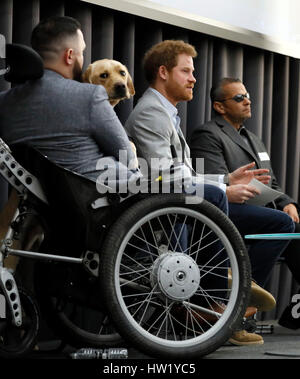 Prinz Harry führt eine Podiumsdiskussion mit ehemaligen Mitgliedern der britischen und US-Streitkräfte, Ivan Castro (rechts), und Philip Eaglesham (links), mit seiner Hilfe Dog Cooper, während der Veterans' Mental Health Conference im King's Building in the Quad, King's College London. Stockfoto