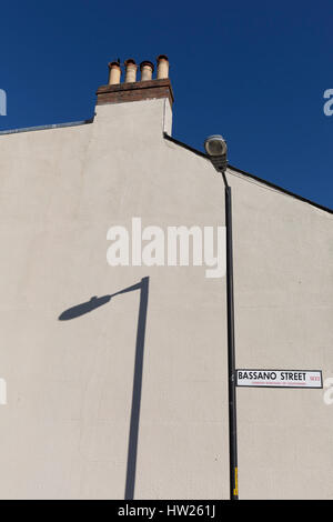 Ein Schatten von einem Laternenpfahl an der weißen Außenwand eines Hauses in East Dulwich, am 15. März 2017, London Borough of Southwark, England. Stockfoto