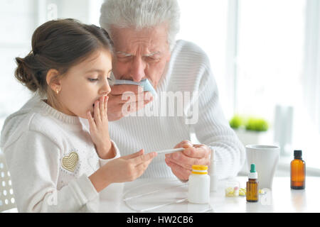 Enkelin kümmert sich um einen kranken Großvater Stockfoto