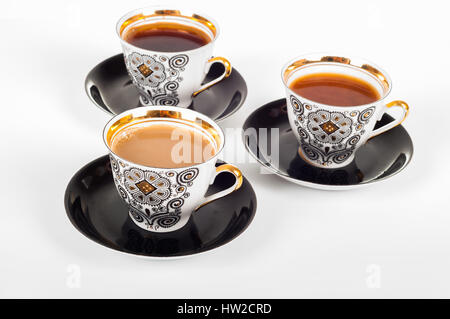 Drei Tassen Kaffee mit schwarzen, weißen und fließende Milch auf weißem Hintergrund Stockfoto