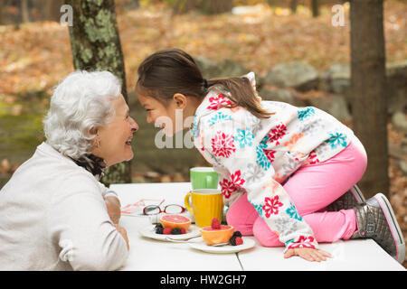 Großmutter und Enkelin spielen am Frühstückstisch im freien Stockfoto