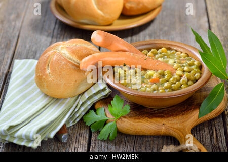 Herzhafte Erbsen-Eintopf mit Kartoffeln, Speck und Wiener Würstchen Stockfoto