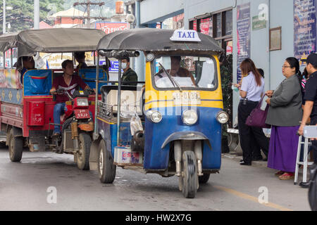 Ein Thai Tuk Tuk kreuzt wieder in Thailand aus Myanmar am Grenzübergang TheMae Sai, gefolgt von einem burmesischen Tuk tuk Stockfoto