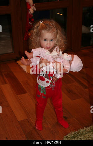 Kleines Mädchen auf Weihnachten Morgen mit Ihrem neuen Baby Annabell Puppe von Santa Stockfoto