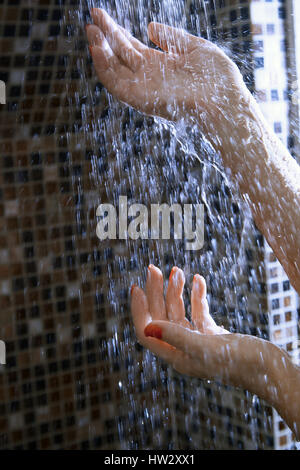 Hände der Frau in der Dusche unter dem fließenden Wasser Stockfoto