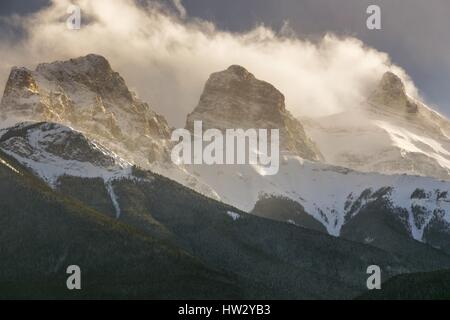 Schnee bedeckte die drei Sisters Mountain Peaks über Canmore Alberta, die von Wolken verdeckt wurden. Bow Valley Winterlandschaft Canadian Rockies Banff National Park Stockfoto