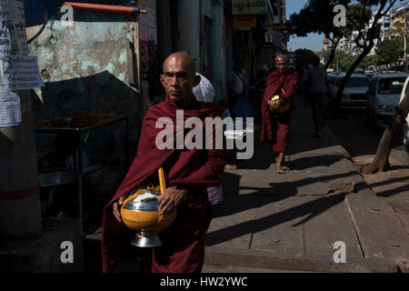 Buddhistische Mönche tragen betteln Schalen durch die Straßen von Yangon Region, Yangon, Myanmar Stockfoto