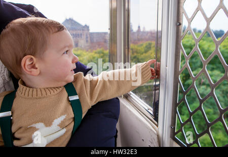 Jungen in der Riesenrad-Kabine. Er ist den hohe Panoramablick beobachtet. Stockfoto