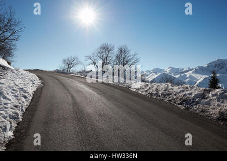 Leere Bergstraße mit Schnee Seiten, blauen Himmel an einem sonnigen Tag Stockfoto