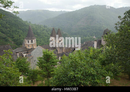 Mittelalterliche Häuser am Hang und der Abtei Kirche der Heiligen Fides (dieAbbatiale Sainte-Foy de Conques) in Conques, Aveyron, Frankreich. Stockfoto