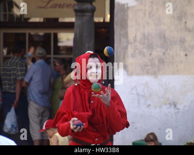 Straße Schauspieler - junge Frau im Clownskostüm Jonglierbälle am alten Marktplatz in Kazimierz Dolny, Polen Stockfoto