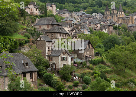 Mittelalterliche Häuser am Hang und der Abtei Kirche der Heiligen Fides (dieAbbatiale Sainte-Foy de Conques) in Conques, Aveyron, Frankreich. Stockfoto