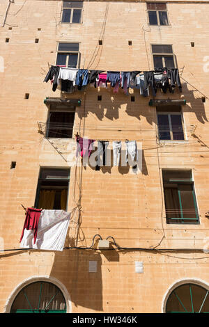 Reinigung und Wäsche hängen zum Trocknen auf Wäscheleinen auf ein altes Gebäude in Valletta Malta Stockfoto