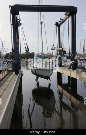 14. MÄRZ 2017, Chichester, England: eine Yacht zu Wasser gelassen, mit einem Boot wiege Schleuder in Chichester marina, England Stockfoto