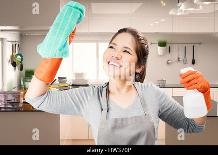 asiatische Haushälterin Reinigung auf Glas mit Küche-Hintergrund Stockfoto