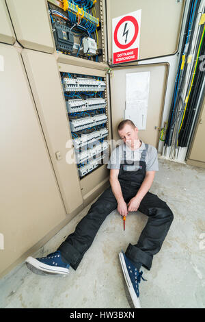 Elektriker mit Elektroschocks auf dem Boden liegend Stockfoto