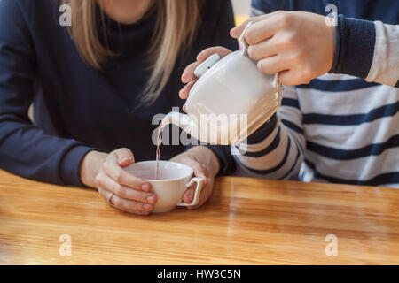 Lieben Sie Versorgung über einander. Schönes paar. Er gießt ihr Früchtetees von Teekanne. Stockfoto