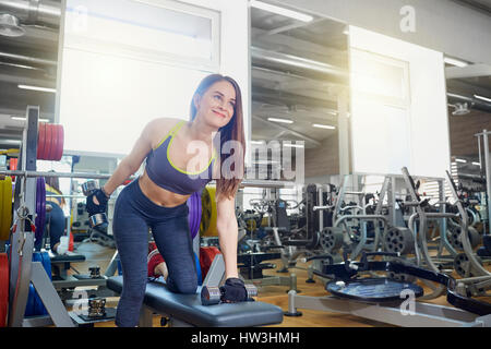 Sportliche Mädchen mit Hanteln in Händen Übungen in spo Stockfoto