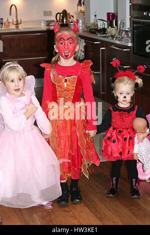 Drei Mädchen Kinder tragen Fee, Teufel und Marienkäfer Kostüme gekleidet an Halloween, Kinderschminken Stockfoto