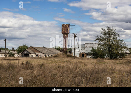 Wasserturm und Schwein Häuser der Kolchose in verlassenen Mashevo Dorf von Tschernobyl Nuclear Power Plant-Zone der Entfremdung in der Ukraine Stockfoto