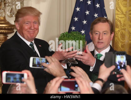 US-Präsident Donald Trump (links) und der irische Premierminister Enda Kenny halten während des St. Patrick's Day Empfangs und der Shamrock Presentation Ceremony im Weißen Haus in Washington DC, USA, eine Schale mit Kleeblättern. Stockfoto