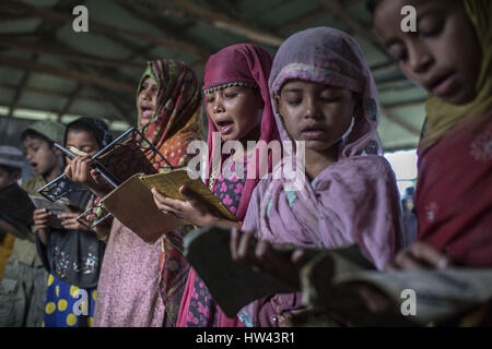 7. März 2017 - Cox Bazar, Chittagong, Bangladesch - Rohingya Flüchtlingskinder im Flüchtlingslager Kutupalang, eine Arabische Schule wo sie lernen lesen Sie den Koran in Cox Bazar, Bangladesch, 7. März 2017. Etwa 70.000 Rohingya-Muslime flohen nach Bangladesch aus Myanmar seit 9. Oktober 2016 nach dem birmanischen Militär Räumungsarbeiten in Reaktion auf einen Angriff auf die Grenzpolizei ins Leben gerufen. Es gibt mehr als 30.000 registrierte Flüchtlinge in Bangladesch aber Behörden schätzen, dass 300.000 bis 500.000 unregistrierte Rohingya sind auch bereits hier leben. Infolgedessen wurden die meisten von diesen unregistere Stockfoto