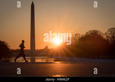 Washington, USA. 17. März 2017. Ein Jogger bei Sonnenaufgang von der National Mall in Washington, USA, 17. März 2017. Die deutsche Bundeskanzlerin Angela Merkel trifft den Präsidenten der USA, Donald Trump, zum ersten Mal im Weißen Haus auf der 17.03.17. Foto: Michael Kappeler/Dpa/Alamy Live News Stockfoto