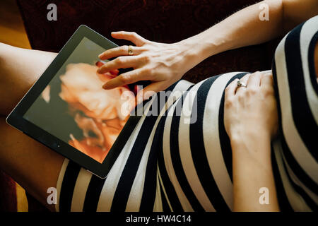 Mittelteil des kaukasischen Schwangere mit digital-Tablette Stockfoto