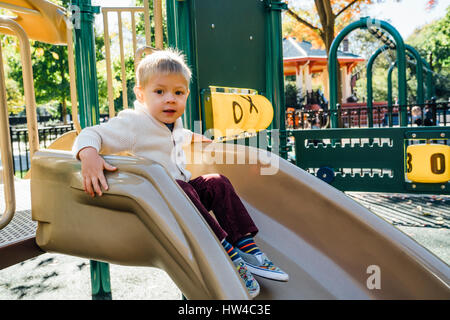 Porträt von Mischlinge Junge sitzt auf der Rutschbahn Stockfoto