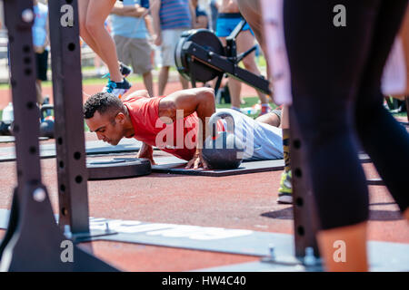 Mann tut Liegestütze in der Nähe von Kettlebell im freien Stockfoto