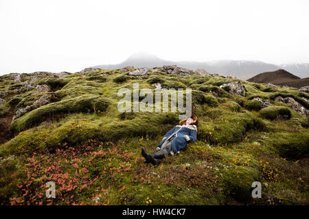 Kaukasische Frau Verlegung auf bemoosten Felsen Stockfoto