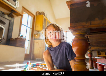 Kaukasische junge spielt mit Spielzeug-Rennstrecke im Stock Stockfoto