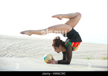 Kaukasische Turnerin balancieren auf Arme am Strand Stockfoto