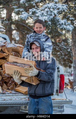 Kaukasische Vater und Sohn tragen Brennholz aus LKW Stockfoto