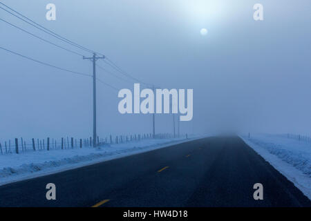 Vollmond über Straße im winter Stockfoto