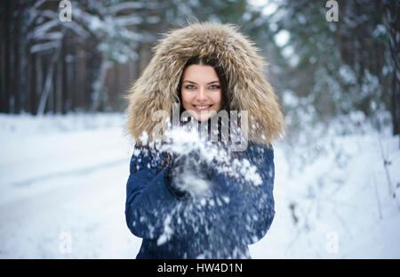 Porträt von verspielten kaukasischen Frau wirft Schnee Stockfoto