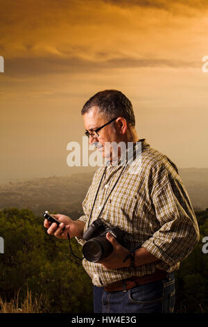 Fotograf assistant Messen das Licht in einem Fotoshooting im Freien bei Sonnenuntergang Stockfoto