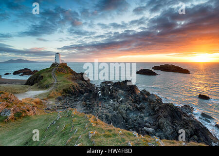 Atemberaubenden Sonnenuntergang über dem Twr Mawr Leuchtturm auf Ynys Llanddwyn auf der Küste von Anglesey in Nord-Wales