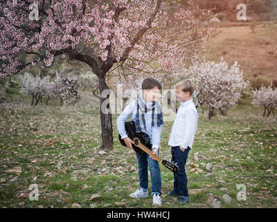 Junge Freunde im Park Gitarre spielen und singen Stockfoto