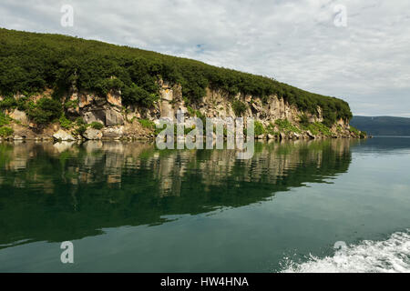 Schöne Küste der Kurilen See spiegelt sich im Wasser. Stockfoto