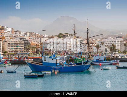 Insel Spanien, Teneriffa, Ruderboote aller Größen und große Fischerboote im Hafen der Stadt, der Promenade in Los Cristianos. Stockfoto