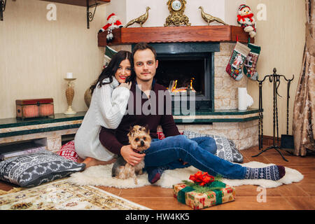 schönes Paar mit kleinen Hund verliebt Kamin Stockfoto