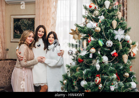 drei Schwestern schmücken den Weihnachtsbaum Stockfoto